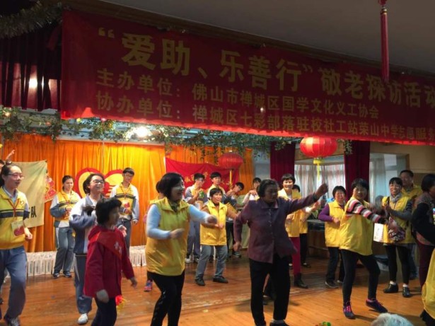 老人和志愿者在表演“小苹果”